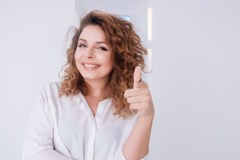 Smiling woman giving thumbs up sign